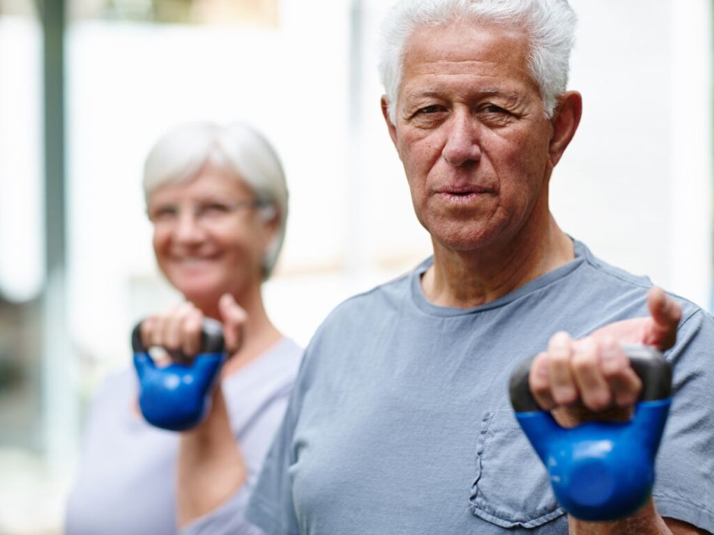 man in his 70s lifting kettlebells