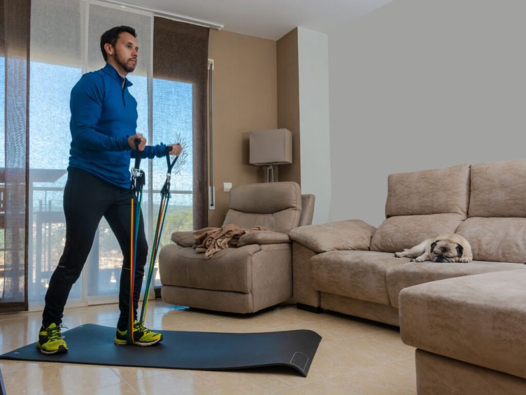 man using resistance bands in his living room