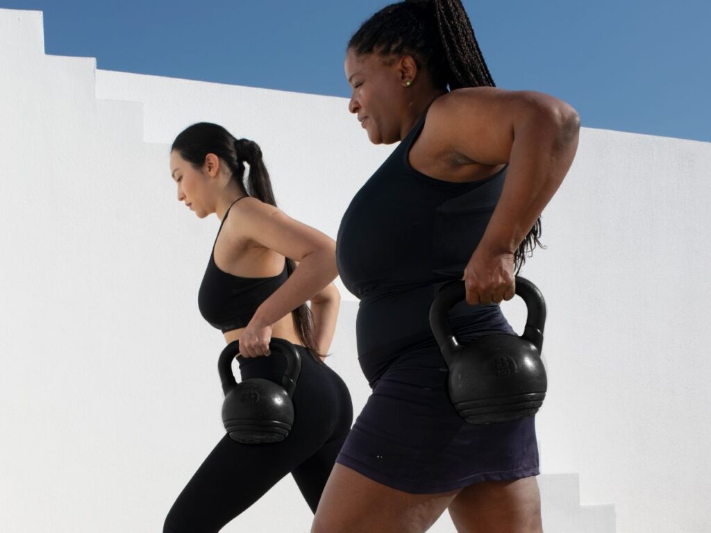 two women lifting kettlebells